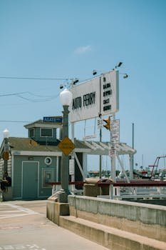 Auto ferry sign on a sunny day at Newport Beach, ideal for summer travel themes.